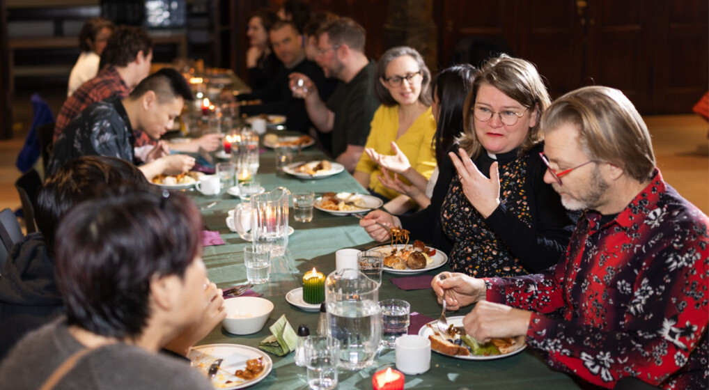 Pastor Maria Fihl sits by the potluck brunch table and talks to her table mates