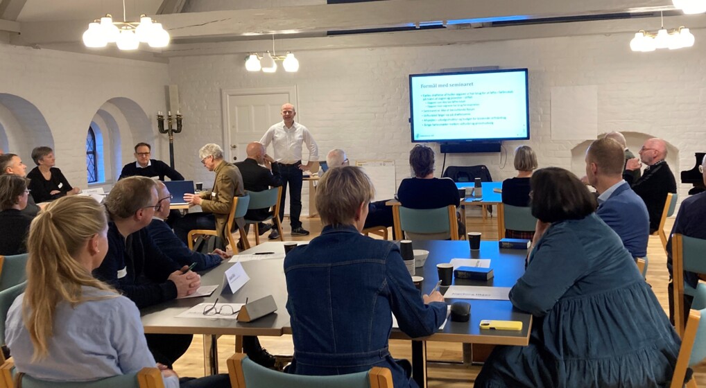 mange mennesker samlet til møde. De kigger mod en oplægsholder