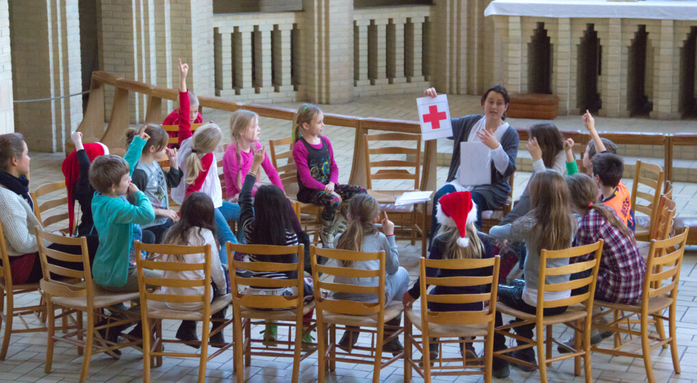 Foran alteret i Grundtvigskirken sidder en flok børn i 7-8 års-alderen og rækker hånden op