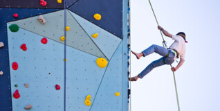 En kvinde hænger i et reb på klatrevæggen ved frederiksholms kirke
