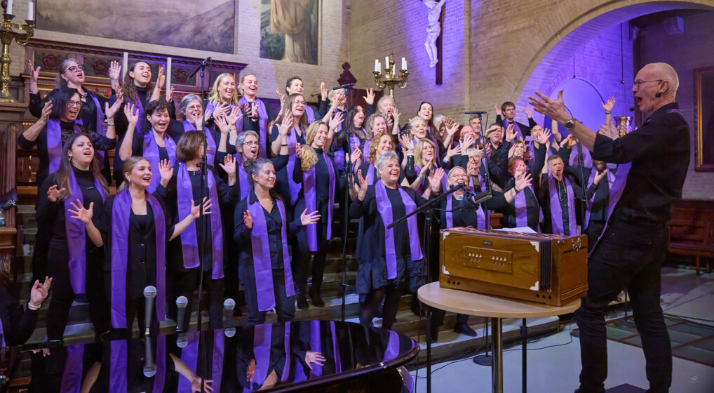 A gospel choir wearing purple scarf swing and sway to the music in a church