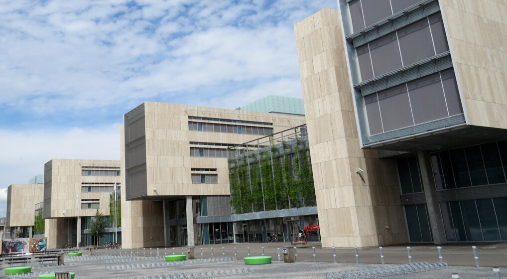 Københavns Universitets Amagers bygninger med en blå sommerhimmel i baggrunden