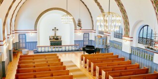 Kapernaumskirken interiør set ovenfra. Kirkerummet er lyst og farverigt med de nyrestaurerede friser på væggene.