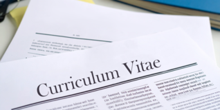 AI-genereret illustration af to stykker papir - den ene med overskriften curriculum vitae - på et rodet skrivebord