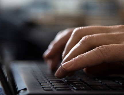 hænder skriver på en bærbar computer