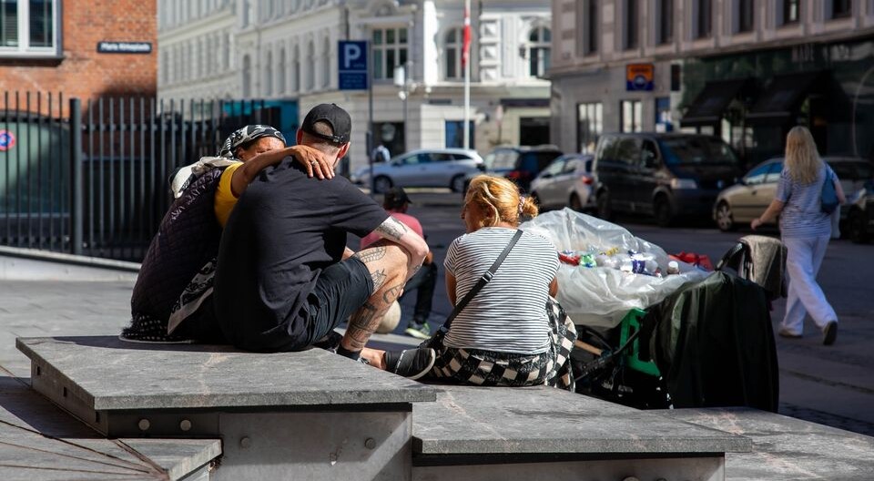 tre mennesker sidder på trappen foran mariakirken på istedgade