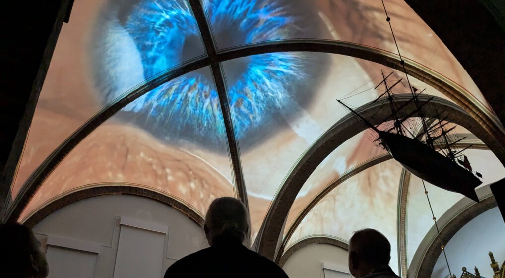 Et øje projiceres på Sct. Andreas Kirkes hvælvinger mens to mennesker betragter billedet nedefra