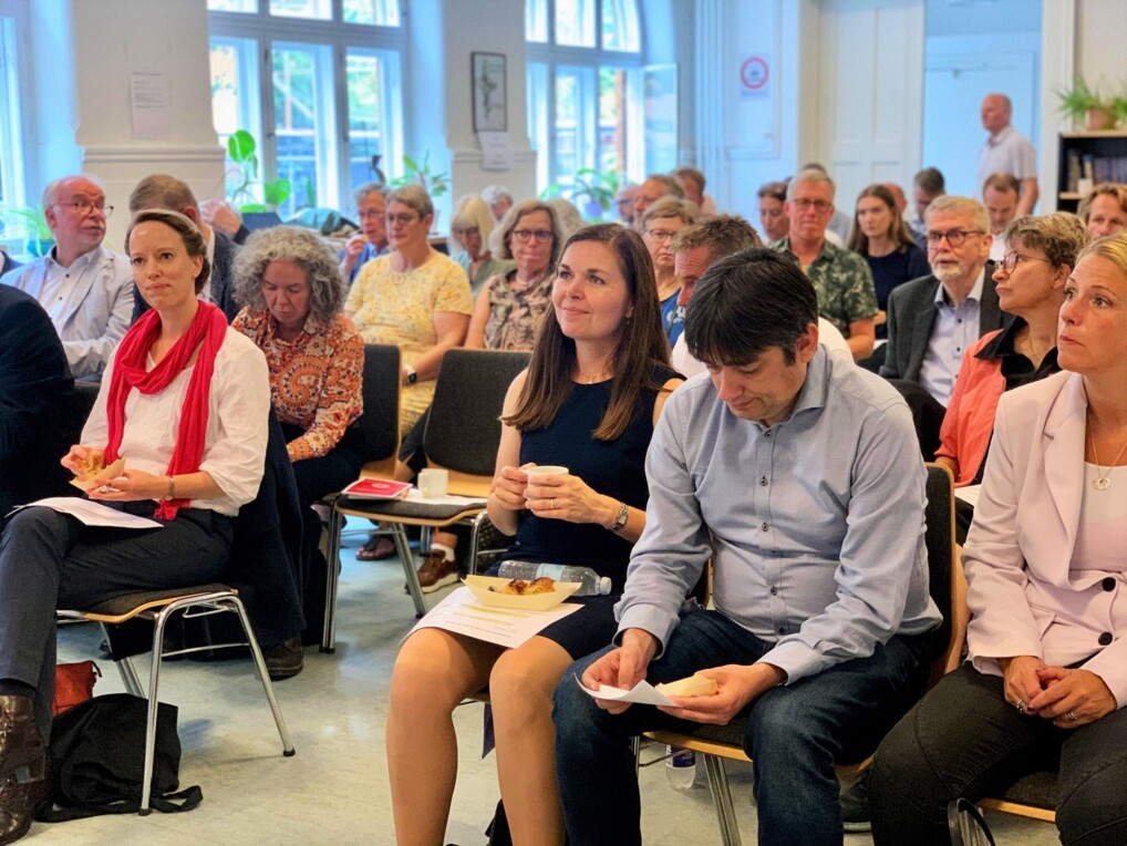 Gruppe af siddende mennesker lytter opmærksomt