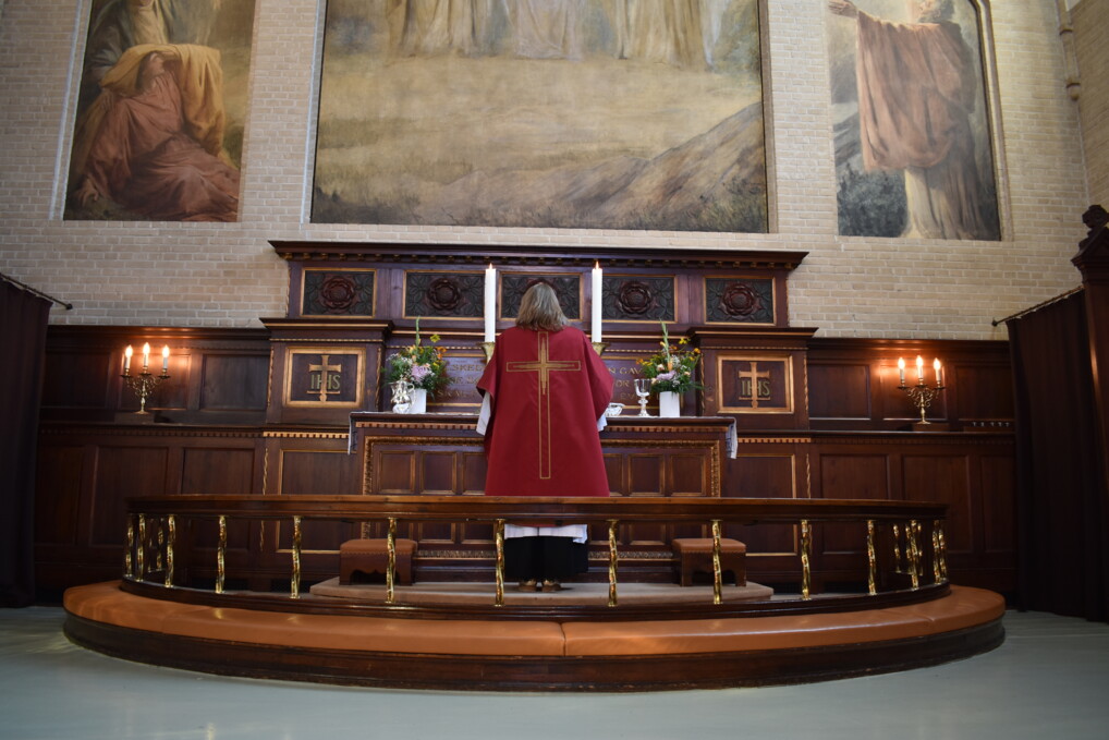Pastor Maria Fihl stands in front of the altar in her special pentecostal pastoral gown